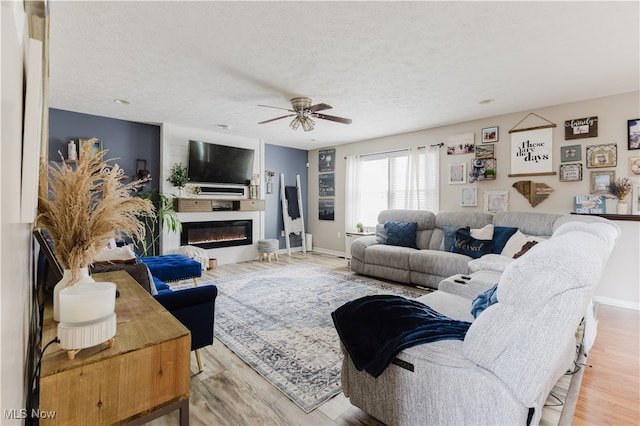 32 Par Three Dr, Follansbee, WV 26037 - living room with a ceiling fan, wood finished floors, a glass covered fireplace, and a textured ceiling