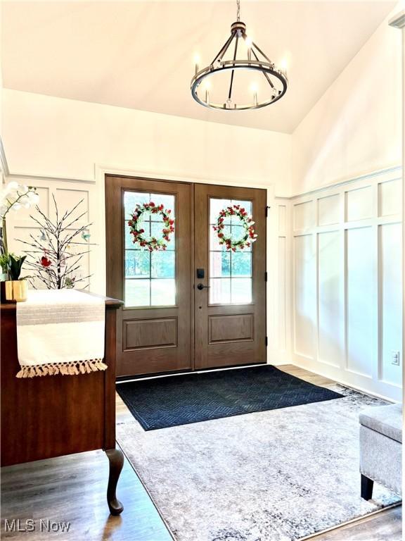 2710 E Hutton Rd, Wooster, OH 44691 - foyer entrance featuring french doors, dark wood-type flooring, a chandelier, a decorative wall, and high vaulted ceiling