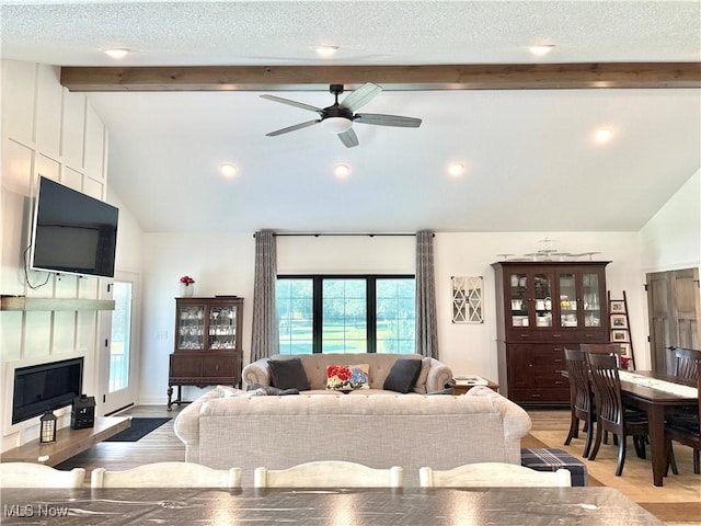 2710 E Hutton Rd, Wooster, OH 44691 - living room featuring beam ceiling, a ceiling fan, a glass covered fireplace, high vaulted ceiling, and light wood-type flooring