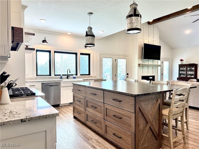 2710 E Hutton Rd, Wooster, OH 44691 - kitchen with stainless steel dishwasher, a kitchen breakfast bar, light wood-style floors, open floor plan, and a center island