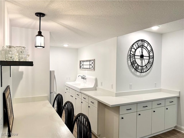 2710 E Hutton Rd, Wooster, OH 44691 - kitchen featuring a textured ceiling, light countertops, pendant lighting, and freestanding refrigerator