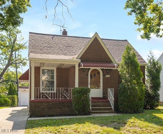 4435 W 58th St, Cleveland, OH 44144 - view of front facade with brick siding, a chimney, a shingled roof, covered porch, and a garage