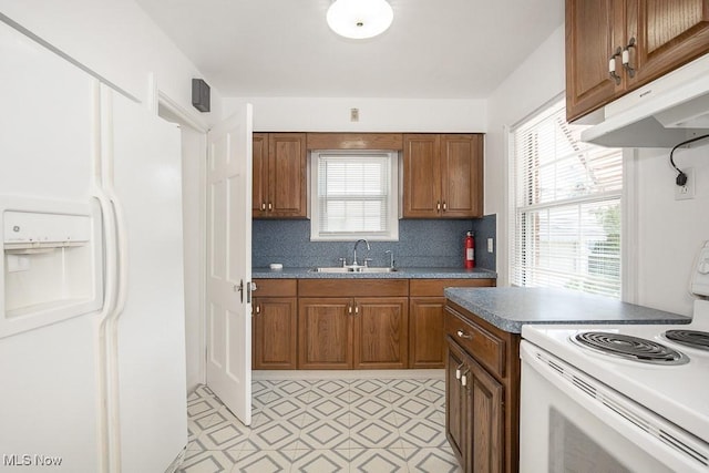 4435 W 58th St, Cleveland, OH 44144 - kitchen featuring white appliances, light floors, under cabinet range hood, and brown cabinetry