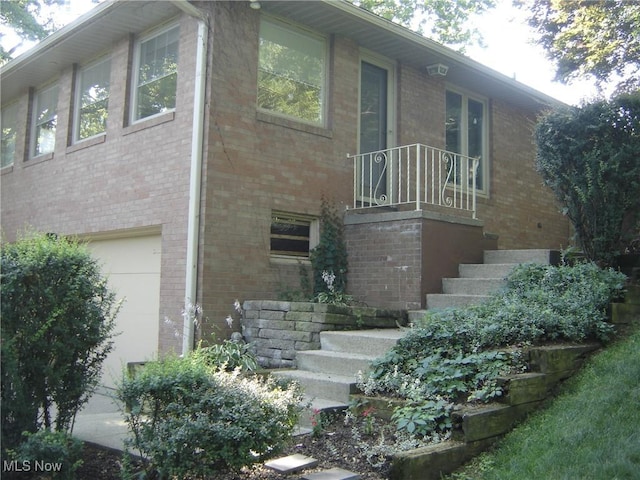 1275 NW Janet Ave, North Canton, OH 44720 - view of side of property with stairs, brick siding, and an attached garage