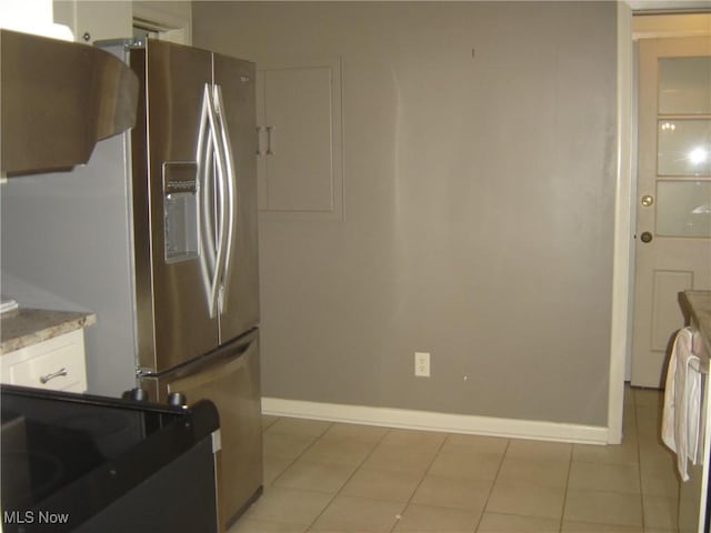 1275 NW Janet Ave, North Canton, OH 44720 - kitchen with stainless steel refrigerator with ice dispenser, white cabinetry, and light tile patterned floors