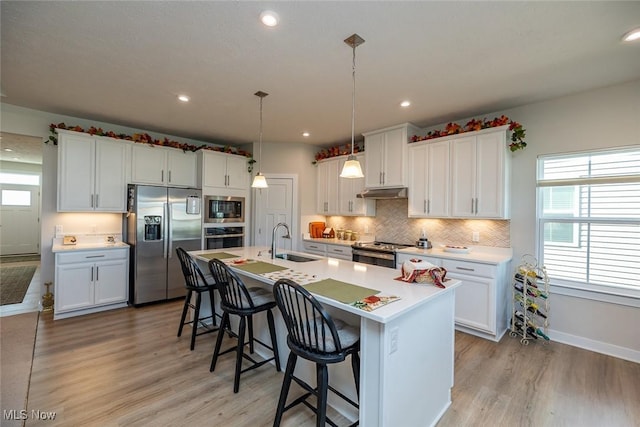 34674 N Legends Way, Grafton, OH 44044 - kitchen with appliances with stainless steel finishes, light wood finished floors, a breakfast bar, white cabinets, and recessed lighting