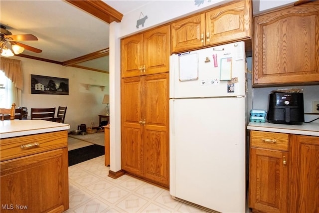 1292 Cinder Rd SE, Bergholz, OH 43908 - kitchen featuring freestanding refrigerator, a ceiling fan, light countertops, brown cabinetry, and ornamental molding