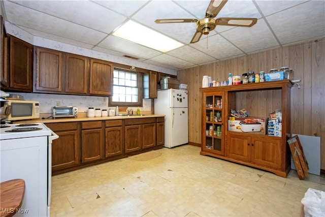 1292 Cinder Rd SE, Bergholz, OH 43908 - kitchen with white appliances, wood walls, light floors, light countertops, and a ceiling fan