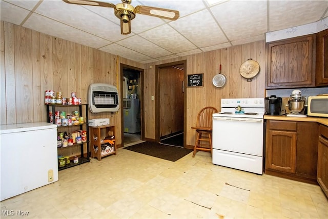 1292 Cinder Rd SE, Bergholz, OH 43908 - kitchen featuring white appliances, wooden walls, light flooring, heating unit, and light countertops