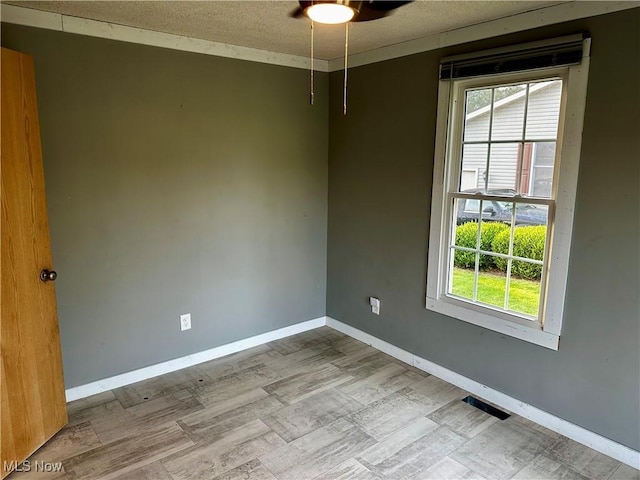 832 Meese Rd NE, Louisville, OH 44641 - unfurnished room featuring healthy amount of natural light, ceiling fan, a textured ceiling, and wood finished floors