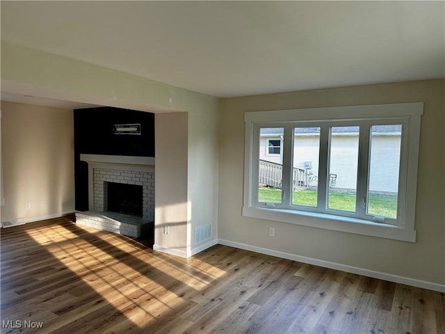 832 Meese Rd NE, Louisville, OH 44641 - unfurnished living room with plenty of natural light, wood finished floors, and a fireplace