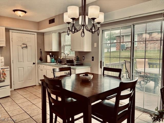 15539 Nantucket Cv # 3, Middlefield, OH 44062 - dining area with light tile patterned flooring, a chandelier, and plenty of natural light