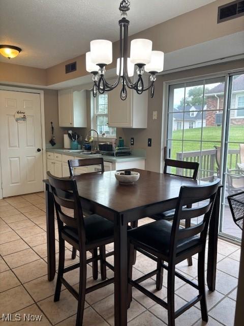 15539 Nantucket Cv # 3, Middlefield, OH 44062 - dining room featuring light tile patterned floors, healthy amount of natural light, a chandelier, and a textured ceiling