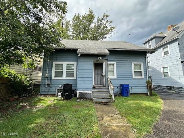 499 E 124th St, Cleveland, OH 44108 - back of house featuring a yard, a shingled roof, and entry steps