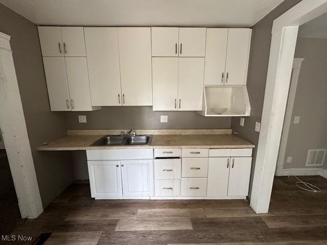 499 E 124th St, Cleveland, OH 44108 - kitchen featuring dark wood-type flooring, white cabinetry, and light countertops