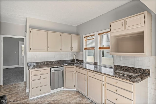4305 W 49th St, Cleveland, OH 44144 - kitchen with stainless steel dishwasher, backsplash, cream cabinets, dark stone counters, and a textured ceiling