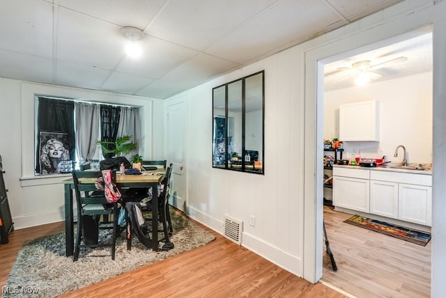 923 Lawton St, Akron, OH 44320 - dining room with light wood-type flooring, ceiling fan, and a decorative wall