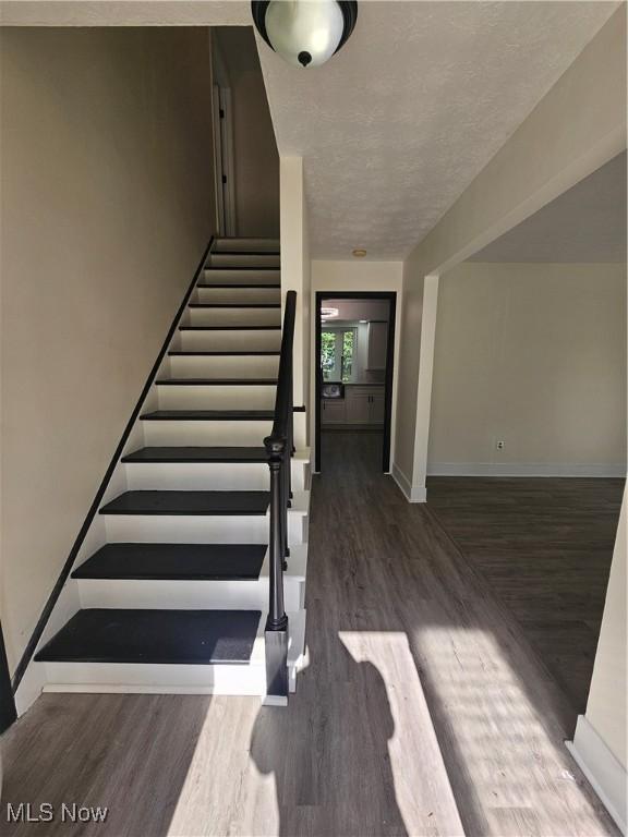 4590 Brendan Ln, North Olmsted, OH 44070 - stairs featuring wood finished floors and a textured ceiling