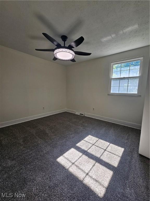 4590 Brendan Ln, North Olmsted, OH 44070 - empty room featuring ceiling fan, dark carpet, and a textured ceiling