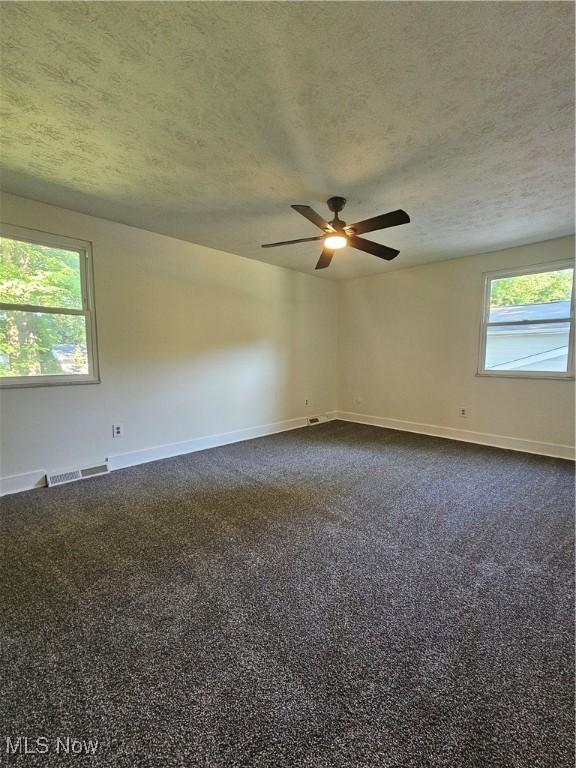 4590 Brendan Ln, North Olmsted, OH 44070 - spare room featuring a textured ceiling, ceiling fan, and dark carpet