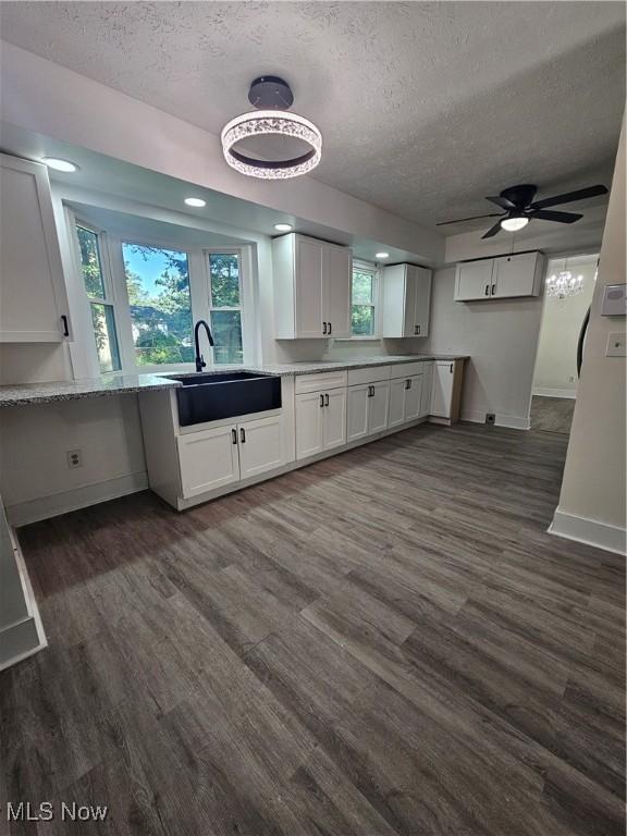 4590 Brendan Ln, North Olmsted, OH 44070 - kitchen with a textured ceiling, white cabinetry, dark wood-style flooring, and ceiling fan