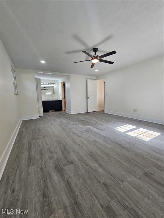 4590 Brendan Ln, North Olmsted, OH 44070 - unfurnished living room featuring dark wood-style floors, recessed lighting, a ceiling fan, and a textured ceiling