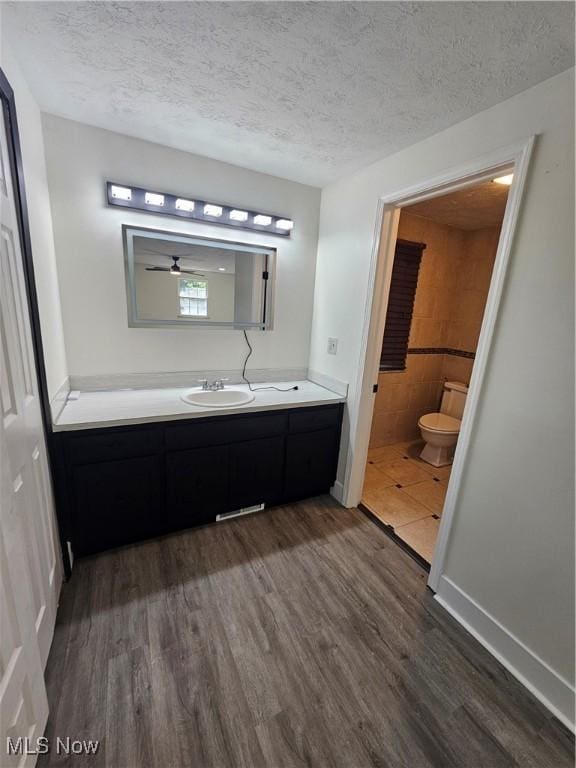 4590 Brendan Ln, North Olmsted, OH 44070 - bathroom featuring wood finished floors, vanity, a textured ceiling, and ceiling fan