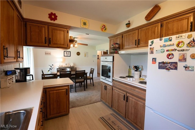 1074 S Meridian Rd, Austintown, OH 44509 - kitchen with white appliances, brown cabinetry, light wood-style flooring, and light countertops