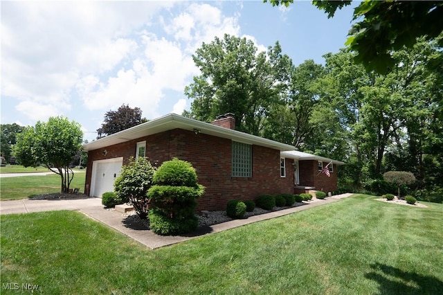 1074 S Meridian Rd, Austintown, OH 44509 - view of home's exterior with an attached garage, a chimney, brick siding, concrete driveway, and a yard