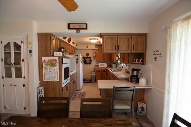 1074 S Meridian Rd, Austintown, OH 44509 - kitchen featuring white appliances, brown cabinets, light countertops, and a peninsula