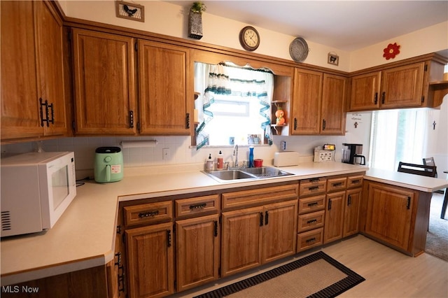 1074 S Meridian Rd, Austintown, OH 44509 - kitchen with white microwave, brown cabinets, a peninsula, and light countertops