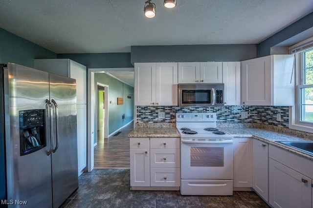 4412 14th Ave, Parkersburg, WV 26101 - kitchen with appliances with stainless steel finishes, white cabinets, tasteful backsplash, and a textured ceiling