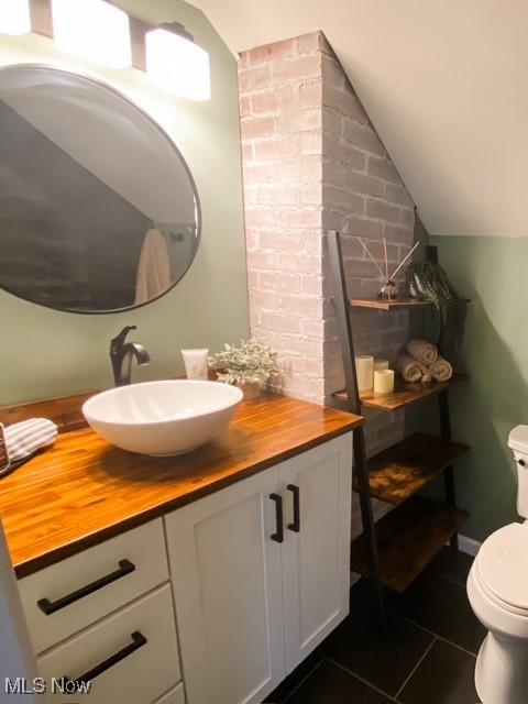 5384 Huron Rd, Lyndhurst, OH 44124 - half bathroom featuring vanity, vaulted ceiling, and tile patterned floors