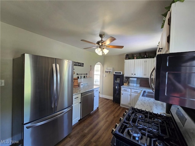 119 E 6th St, Williamstown, WV 26187 - kitchen with black appliances, arched walkways, ceiling fan, white cabinetry, and dark wood-type flooring