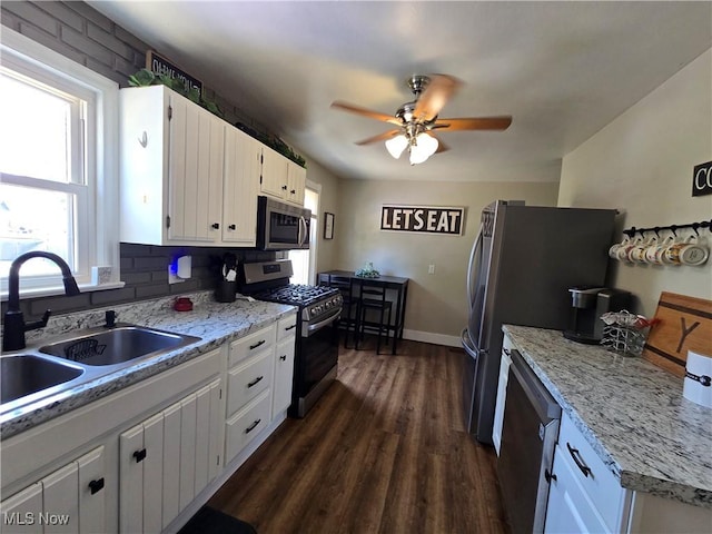 119 E 6th St, Williamstown, WV 26187 - kitchen featuring stainless steel appliances, white cabinets, dark wood-style floors, a ceiling fan, and tasteful backsplash