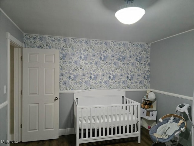 119 E 6th St, Williamstown, WV 26187 - bedroom featuring wood finished floors, wallpapered walls, and wainscoting