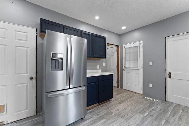 4010 11th Ave, Parkersburg, WV 26101 - kitchen with stainless steel refrigerator with ice dispenser, light wood-style flooring, blue cabinets, a textured ceiling, and recessed lighting