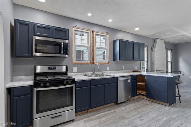 4010 11th Ave, Parkersburg, WV 26101 - kitchen featuring appliances with stainless steel finishes, a peninsula, a breakfast bar, light wood-style floors, and recessed lighting