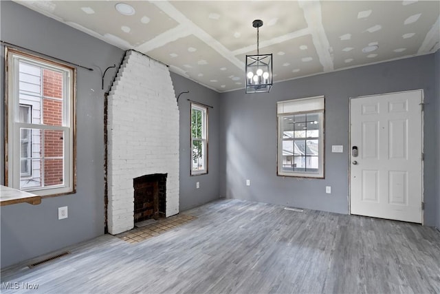 4010 11th Ave, Parkersburg, WV 26101 - unfurnished living room featuring wood finished floors, a fireplace, and a chandelier