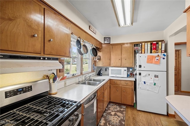 34 Prospect St, Seville, OH 44273 - kitchen with stainless steel appliances, light wood-type flooring, light countertops, brown cabinetry, and range hood