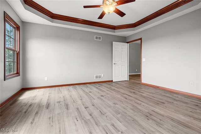 4428 Trail Head Cir NW, Massillon, OH 44647 - empty room with a tray ceiling, crown molding, a ceiling fan, and light wood-style floors