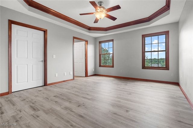 4428 Trail Head Cir NW, Massillon, OH 44647 - unfurnished bedroom with a tray ceiling, ornamental molding, multiple windows, and light wood-style flooring