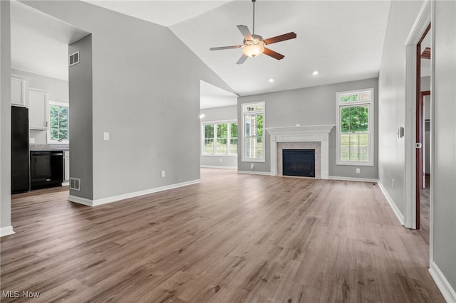 4428 Trail Head Cir NW, Massillon, OH 44647 - unfurnished living room featuring a ceiling fan, light wood-style flooring, a tile fireplace, and high vaulted ceiling