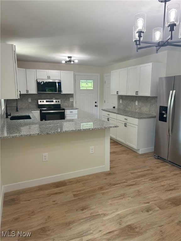 9822 Hooper Rd, Athens, OH 45701 - kitchen featuring appliances with stainless steel finishes, backsplash, light stone countertops, and light wood-style floors
