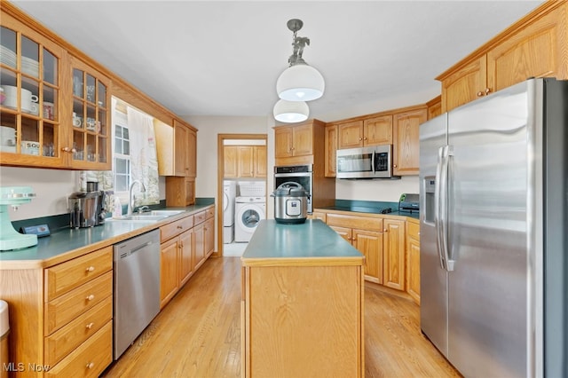1133 S Azalea Blvd, Barberton, OH 44203 - kitchen with appliances with stainless steel finishes, washer and clothes dryer, a kitchen island, light wood finished floors, and glass insert cabinets