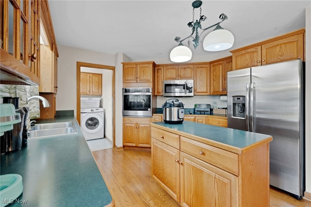 1133 S Azalea Blvd, Barberton, OH 44203 - kitchen with stainless steel appliances, washer / dryer, a center island, light wood-type flooring, and pendant lighting