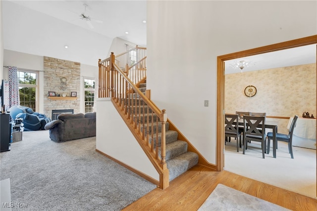 1133 S Azalea Blvd, Barberton, OH 44203 - stairs featuring a fireplace, wood finished floors, high vaulted ceiling, ceiling fan, and carpet floors