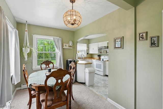 1624 Krumroy Rd, Akron, OH 44306 - dining room with a chandelier, arched walkways, a baseboard heating unit, and light carpet
