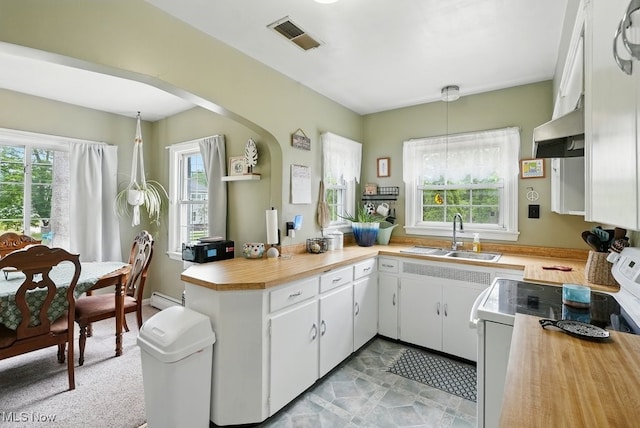 1624 Krumroy Rd, Akron, OH 44306 - kitchen featuring white electric range oven, under cabinet range hood, a peninsula, wood counters, and white cabinetry