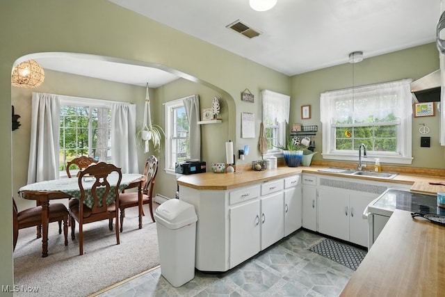 1624 Krumroy Rd, Akron, OH 44306 - kitchen with arched walkways, light countertops, white cabinetry, a peninsula, and pendant lighting
